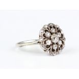 A diamond cluster ring in an openwork flowerhead shaped design, mounted with the principal cushion