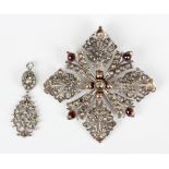 A jargoon and garnet pendant, probably Indian, in a quatrefoil shaped pierced openwork design,