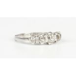 A platinum and diamond five stone ring, claw set with a row of cushion cut diamonds graduating in