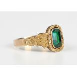 A Victorian gold and foil backed green paste ring with scroll engraved decoration to the