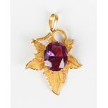 A gold and synthetic colour change corundum filigree pendant, designed as a leaf, detailed '23K',