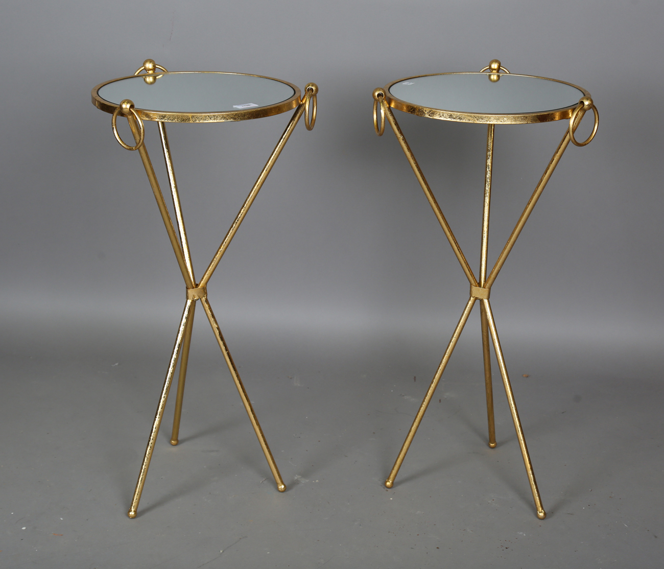 A pair of modern gilt painted metal mirror-topped stands, height 75cm, diameter 36cm.Buyer’s Premium