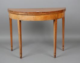 A George III ash demi-lune fold-over card table with crossbanded borders and inlaid conch shell,