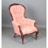 A mid-Victorian walnut showframe armchair, upholstered in modern buttoned fabric, on carved cabriole