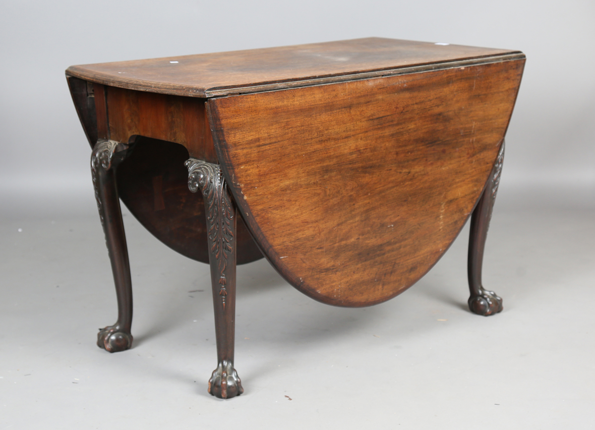 A George III Irish mahogany oval drop-flap dining table, the cabriole legs finely carved with