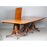 A late George III mahogany triple pillar dining table, raised on turned supports and carved legs,