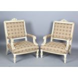 A pair of early 20th century white and gilt painted showframe armchairs with lion mask handrests,