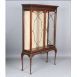 An early 20th century mahogany glazed display cabinet with blind fretwork frieze and carved cabriole