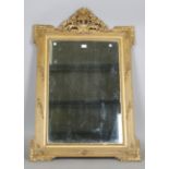 An early 20th century Neoclassical Revival gilt composition wall mirror with a bevelled glass plate,
