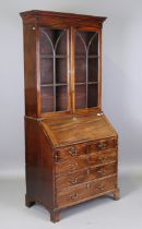 A George III mahogany bureau bookcase, the glazed top above a fall flap and an arrangement of oak-