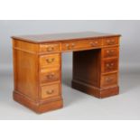 A 20th century mahogany twin pedestal desk, inset with gilt-tooled leather above an arrangement of