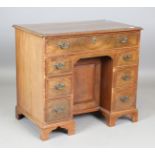 A George III mahogany kneehole desk, fitted with an arrangement of oak-lined drawers and central