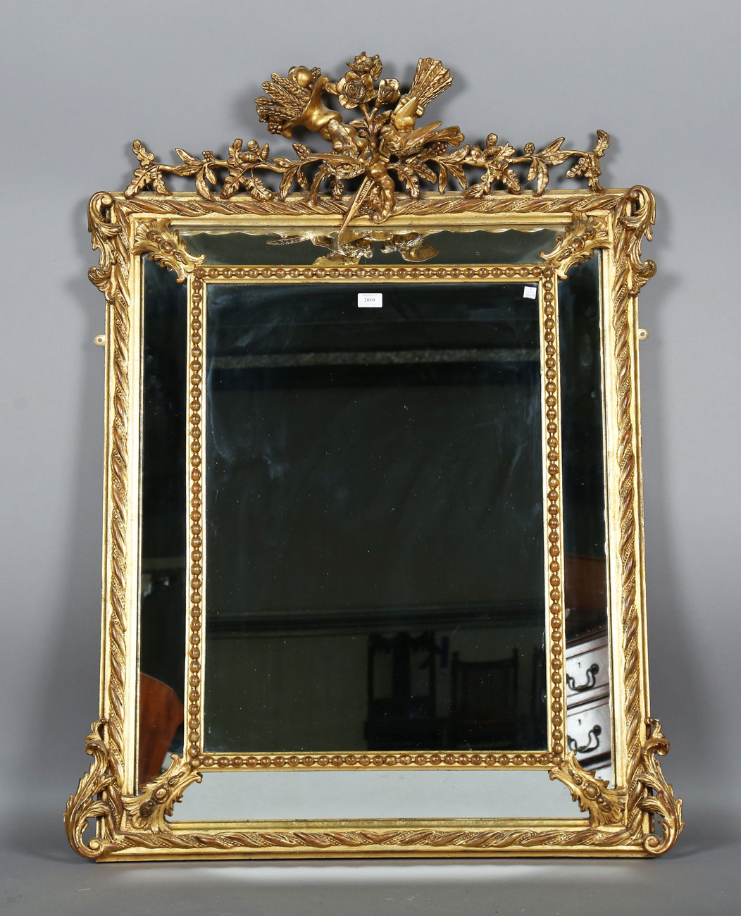 A 19th century gilt composition sectional wall mirror with a bird and quiver surmount above a beaded