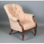 A William IV mahogany framed button back armchair, raised on reeded baluster legs and castors,
