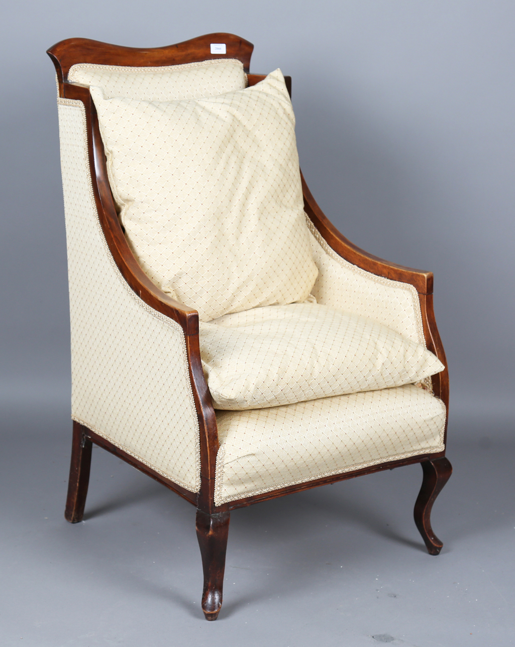 An Edwardian walnut framed armchair, upholstered in cream damask, height 109cm, width 65cm, together