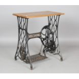 A Singer sewing machine treadle base, converted to a table and fitted with an oak top, height