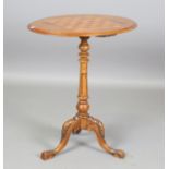 A late Victorian walnut oval games occasional table, the top inlaid with a chessboard, on a carved