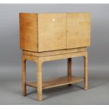 An Art Deco walnut cabinet, in the manner of Gordon Russell, the two doors with geometric veneer,