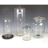 A mid-20th century cylindrical glass jar and cover, height 53cm, a similar smaller example,