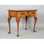 A George I walnut and crossbanded kneehole lowboy, fitted with three drawers above a fretwork apron,