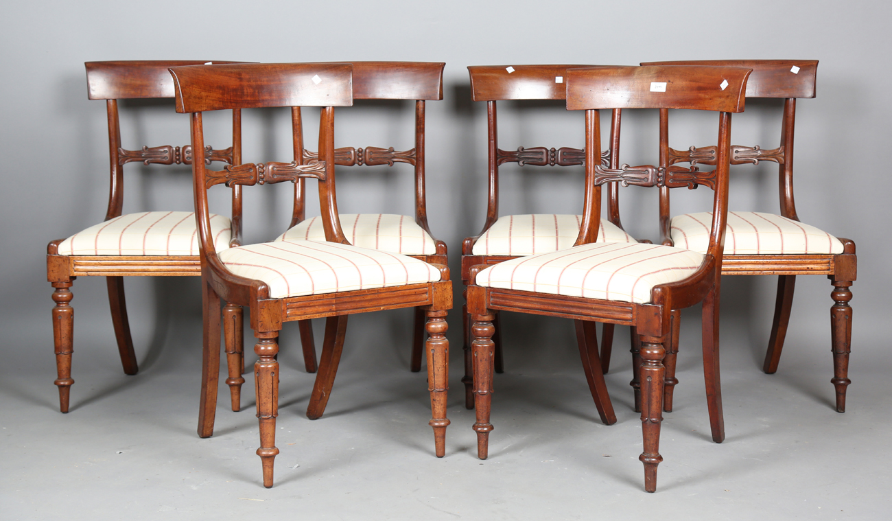 A set of six Regency mahogany bar back dining chairs with finely carved tulip cusp centre rails