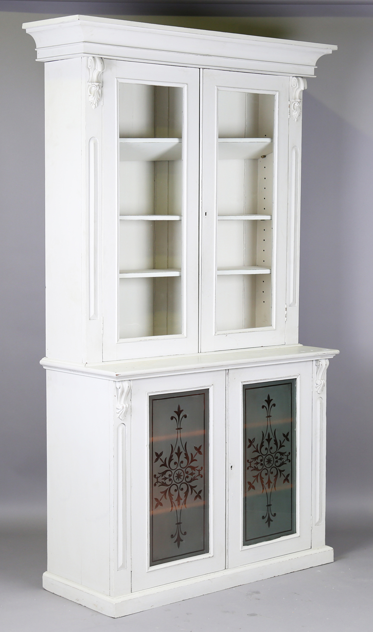 A late 19th century grey painted bookcase cabinet with carved foliate mouldings and frosted glass