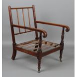 A George IV mahogany framed armchair, raised on ring turned legs and castors, height 95cm, width