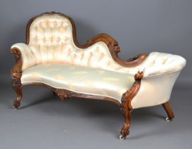 A fine mid-Victorian walnut showframe salon settee, the frame carved with flowers, leaves and fruit,