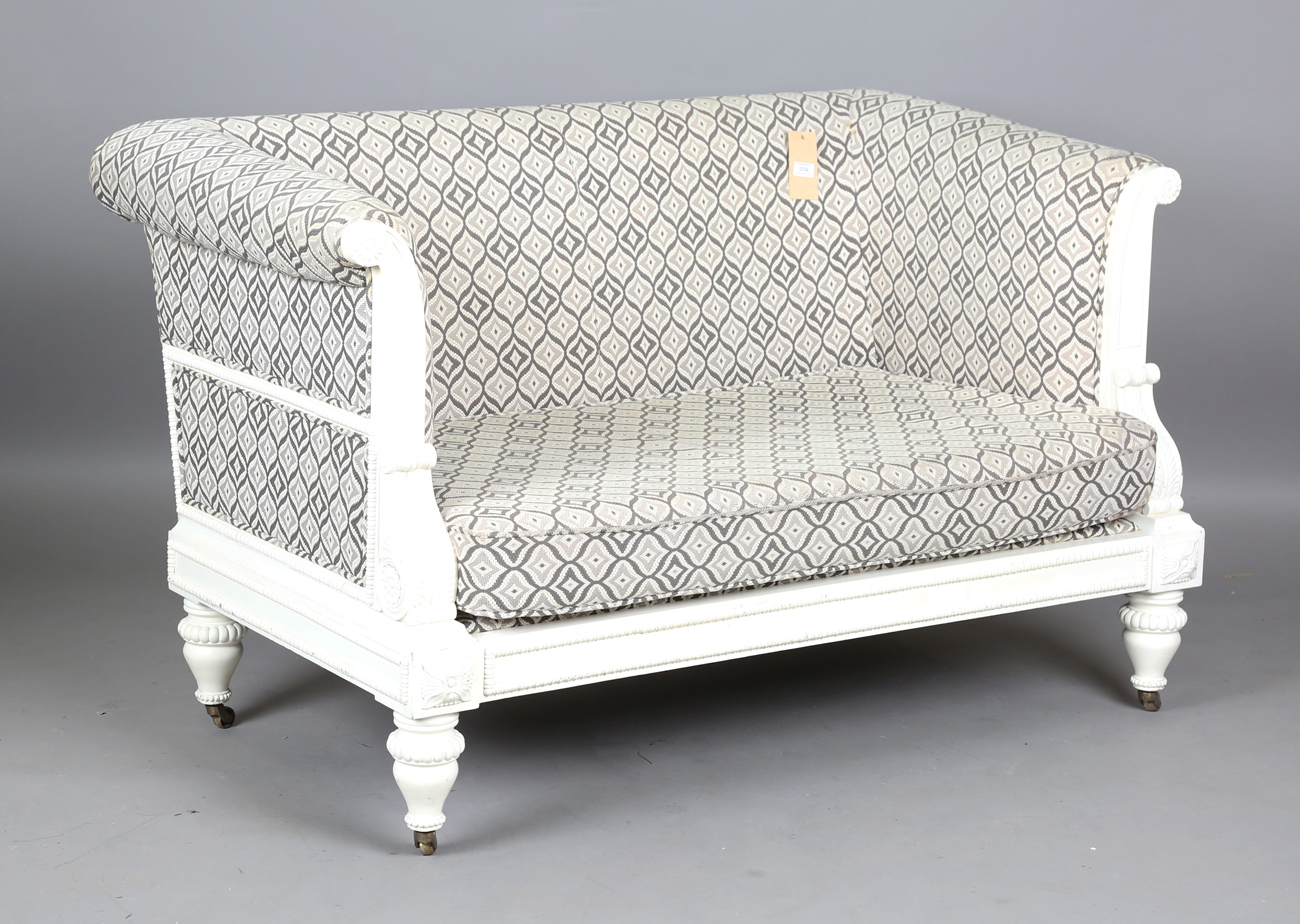 A modern Julian Chichester Regency style white painted showframe two-seat settee, the frame carved