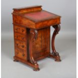 A mid-Victorian walnut Davenport, fitted with four side drawers and raised on carved scroll