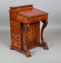 A mid-Victorian walnut Davenport, fitted with four side drawers and raised on carved scroll
