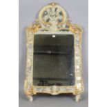 A 19th century Continental green painted and gilded wall mirror, the shaped crest carved with a