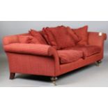 A large modern sofa, upholstered in claret fabric, raised on gilt metal mounted feet and castors,