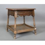 An early 20th century Arts and Crafts style oak two-tier occasional table, the top decorated with