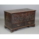 A 19th century oak mule chest, the hinged lid above a carved front, fitted with two drawers,