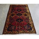 A Hamadan rug, North-west Persia, late 20th century, the aubergine field with overall medallions,