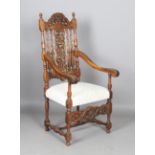 An early 20th century French walnut framed open armchair, the foliate carved back above an