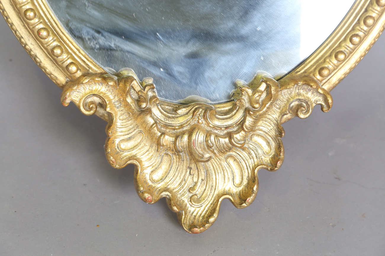 A 20th century rococo style gilt composition oval wall mirror with a shell surmount and scroll - Bild 3 aus 4