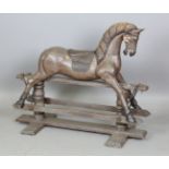 A 20th century painted wooden rocking horse with carved mane and embossed leather saddle, on a swing