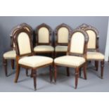 A set of eight late Victorian Gothic Revival walnut dining chairs with finely carved frames,