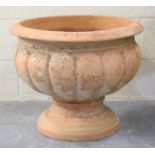 A 20t century terracotta garden urn with a lobbed circular body on a spreading circular foot, height