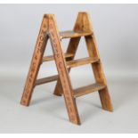 A modern softwood stepladder, the sides sign-written with champagne advertising, height 81cm,