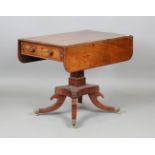 A Regency mahogany single-pedestal Pembroke table, the downswept legs with foliate cast brass caps