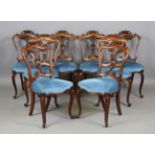 A set of eight mid-Victorian rosewood framed carved spoon back dining chairs with overstuffed seats,