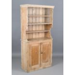 A 20th century narrow pine dresser, the shaped sides above two cupboard doors, height 191cm, width