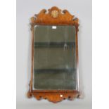 A 20th century Queen Anne style walnut fretwork wall mirror, the frame with a carved parcel gilt