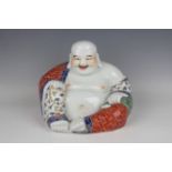 A Chinese famille rose porcelain figure of a seated smiling Buddha, early 20th century, modelled