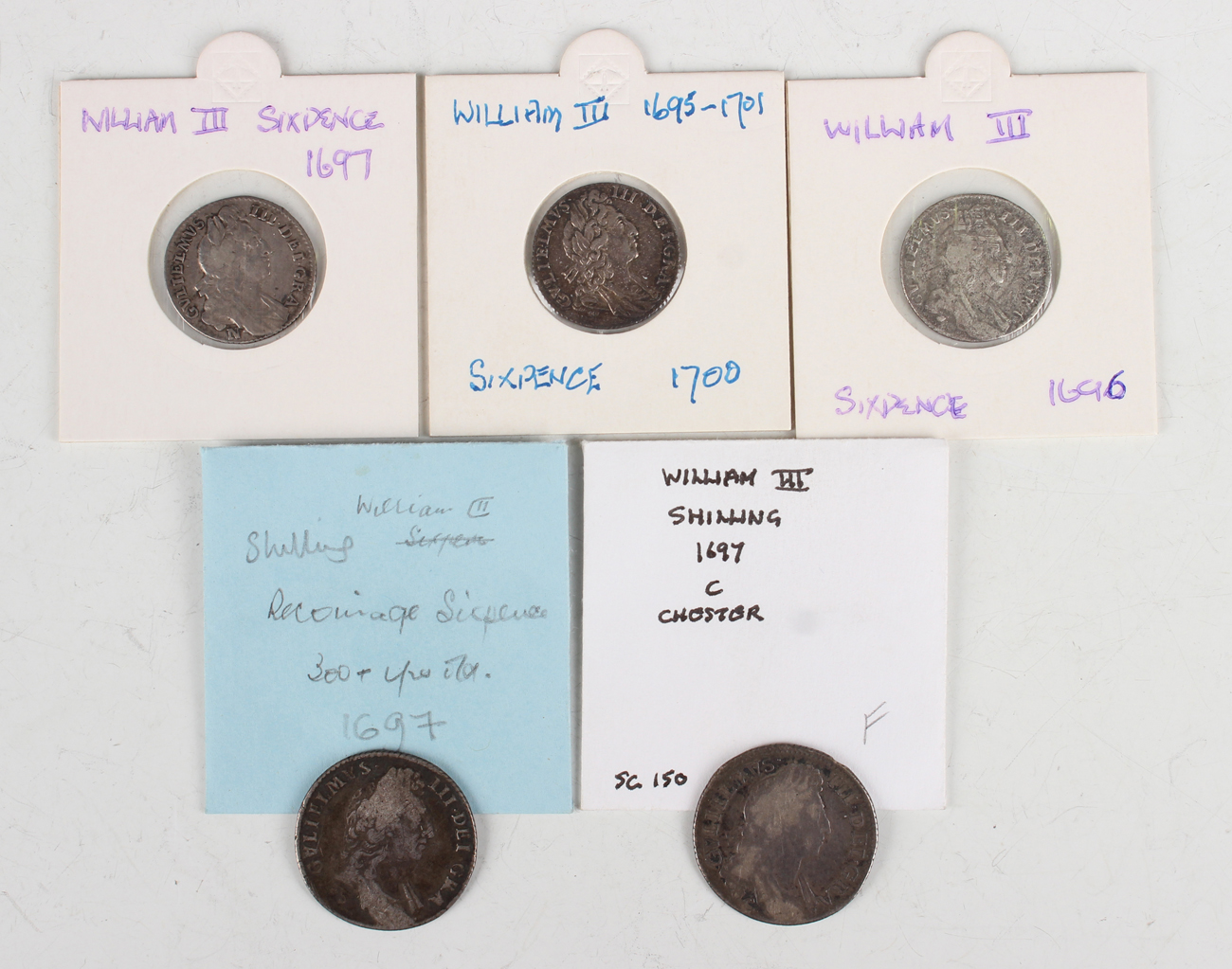 A William III sixpence 1700, two other sixpences, 1696 and 1697, and two shillings, both 1697.