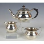 A George V silver three-piece tea set of squat circular form, comprising teapot, two-handled sugar