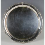 A George V silver circular salver with cast stylized flower and scrolling leaf rim, Sheffield 1935